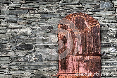 Rusty Old Door On Rock Wall