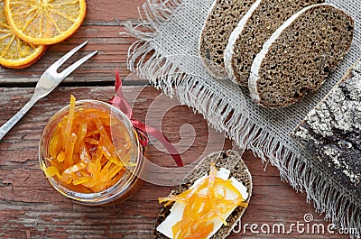 Rye bread with butter and homemade orange confiture on rusted wo