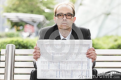 Sad businessman with newspaper in his hands