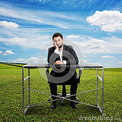 Sad businessman sitting at table