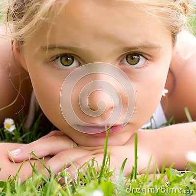 A sad child girl in grass