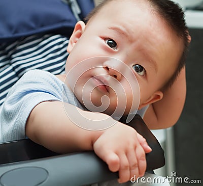 Sad cute asian baby watching out