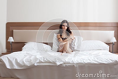 Sad girl in leopard print negligee lying on bed