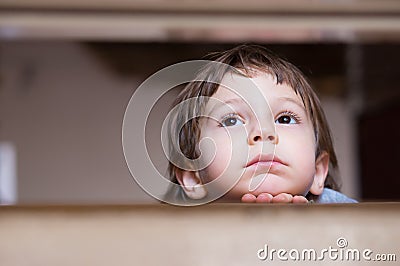 Sad little boy thinking looking up