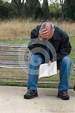Sad man holding bible