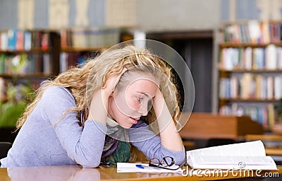 Sad student working in library