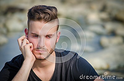 Sad or worried young man outdoors