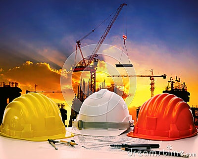Safety helmet on civil engineer working table against crane lift
