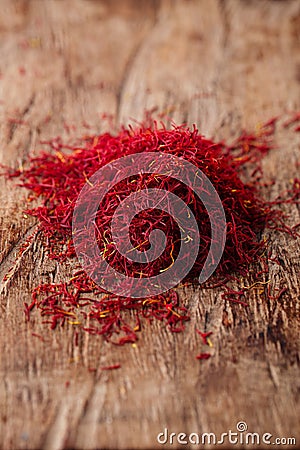 Saffron spice in pile on old wooden background