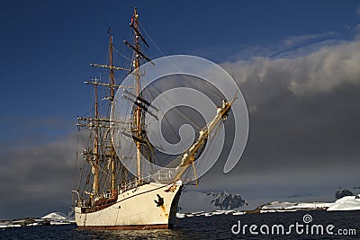 Sailing ship on the background of the mountains of the Antarctic