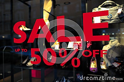 Sale (up to 50 off) sign in a fashion shop window