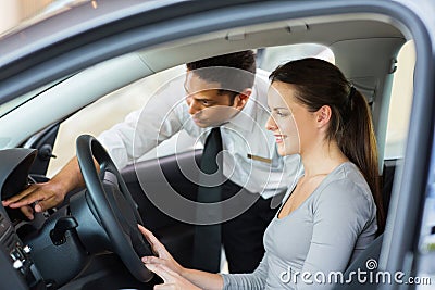 Salesman explaining car features customer