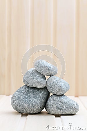 Sauna stones. Stacked on a wooden surface.