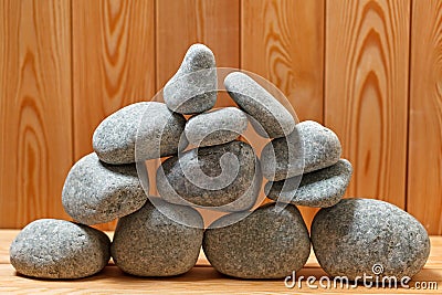 Sauna stones. Stacked on a wooden surface.