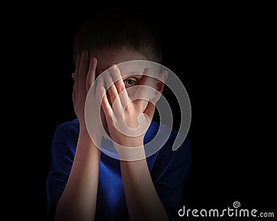 Scared Little Child Covering Eyes on Black