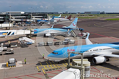 Schiphol airport with workers and departing and ar
