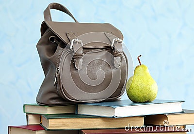 School backpack with books and pear, close-up