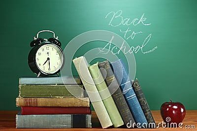 School Books, Apple and Clock on Desk at School