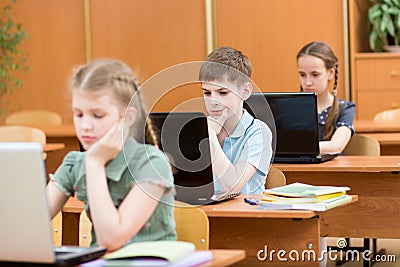 School kids using laptop at lesson