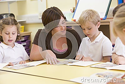 Schoolchildren and their teacher reading in class