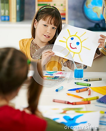 Schoolgirl showing painting in art class