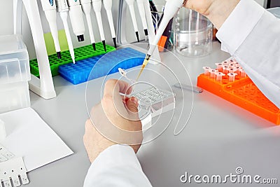 Scientist with dropper working at the laboratory
