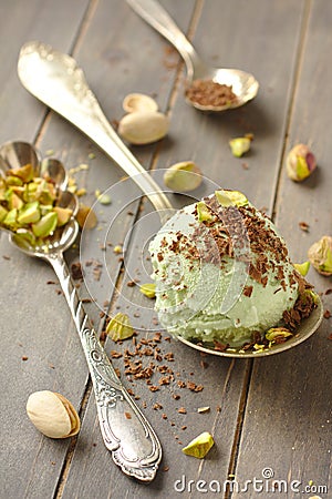 Scoop of homemade pistachio ice cream with chopped pistachios and chocolate