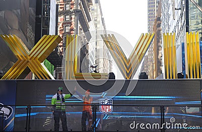 Seattle Seahawlks and Denver Broncos fans posing for picture next to Roman Numerals on Broadway during Super Bowl XLVIII week