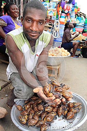 Seller of giant snails on African market