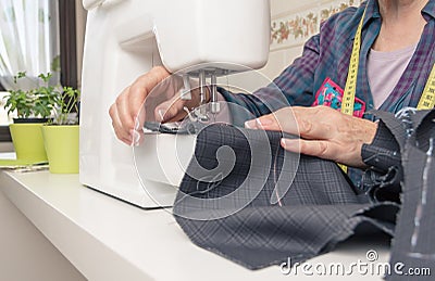 Senion seamstress woman working on sewing machine