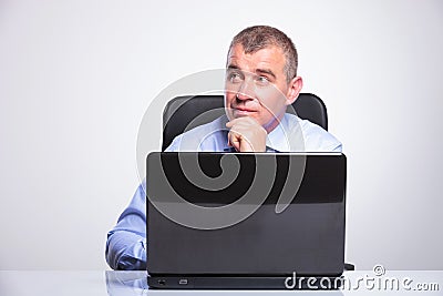 Senior business man is pensive at laptop