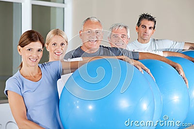 Senior citizens holding gym balls