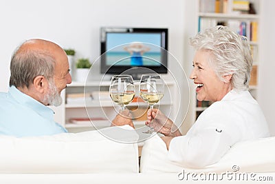Senior couple celebrating with white wine