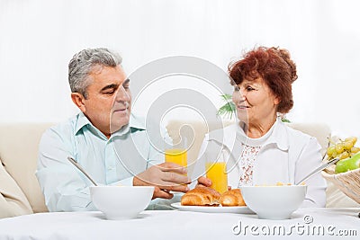 Senior couple drink orange juice breakfast