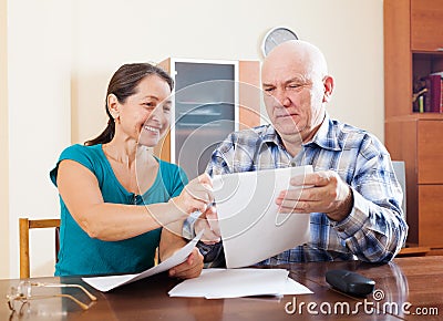Senior couple holding financial documents