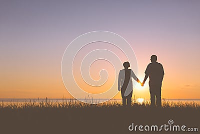 Senior couple holding hands silhouettes