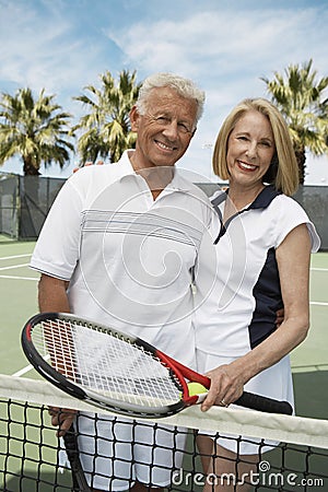 Senior Couple Holding Tennis Racquets