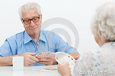 Senior couple playing with cards