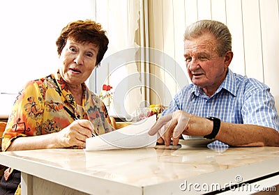 Senior couple signing document