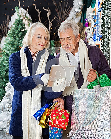 Senior Couple Using Digital Tablet At Christmas