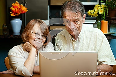 Senior couple using laptop computer at home