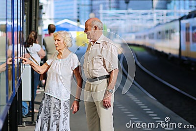 Senior couple waiting for train at railway station