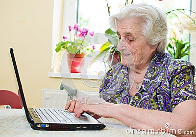 The senior hand presses the laptop keyboard