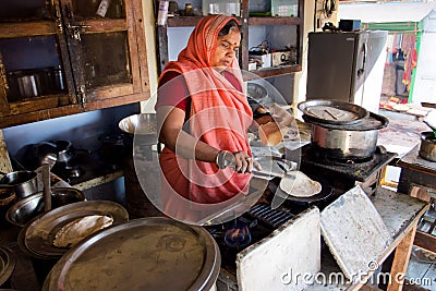 Senior indian lady in sari dress cooking