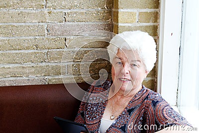 Senior lady reading tablet