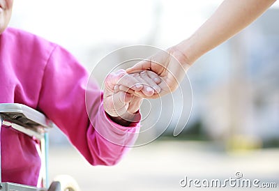 Senior Lady in Wheelchair Holding Hands