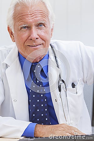 Senior Male Doctor With Stethoscope at Desk & Computer