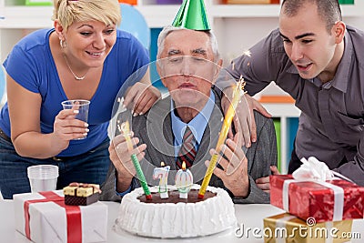 Senior man blowing candles