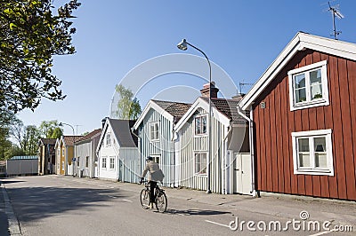 Senior man cycling by wooden houses