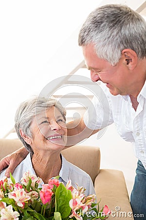 Senior man giving his partner a bouquet of flowers